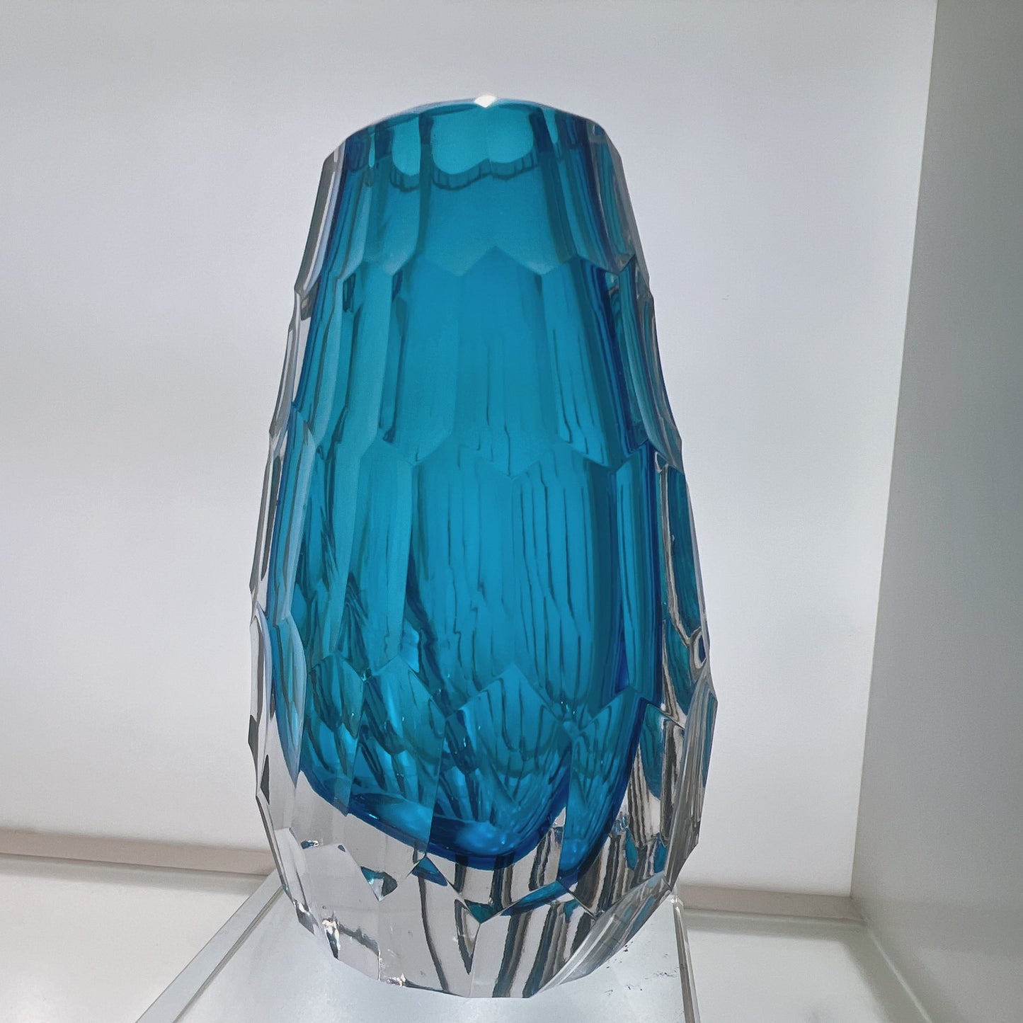 Blue glass vase with textured design on a white background