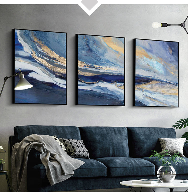 Three abstract paintings above a sofa in a living room setting.
