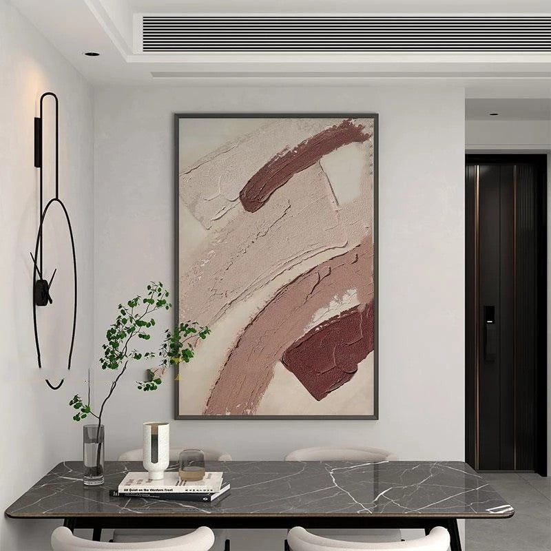 Abstract art piece on a wall above a dining table with decor items.