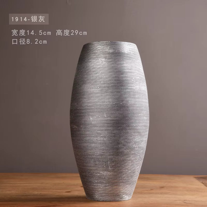 Silver textured vase on a wooden surface with a gray background