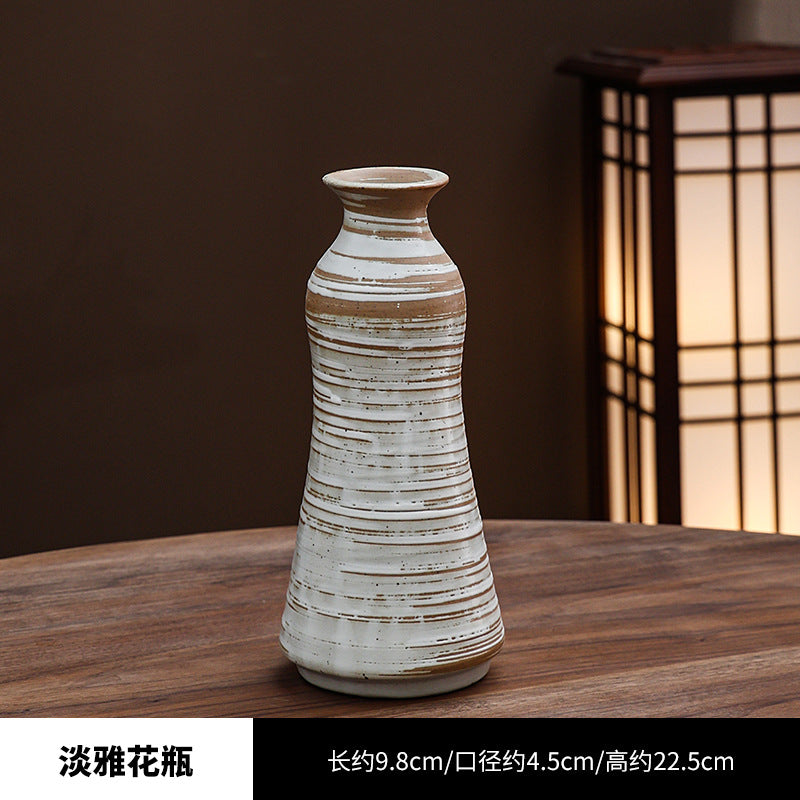 Ceramic vase with striped design on a wooden table, blurred background