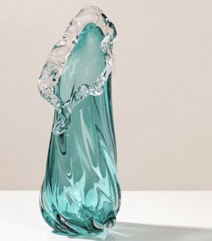 Turquoise glass sculpture on a beige background