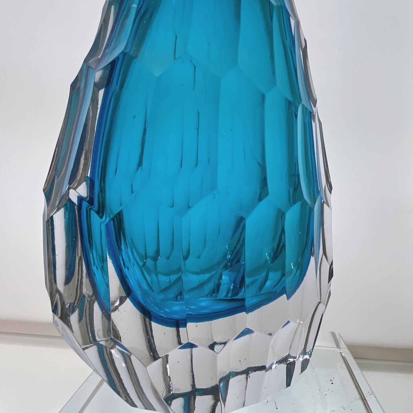Blue and clear glass vase on a white background