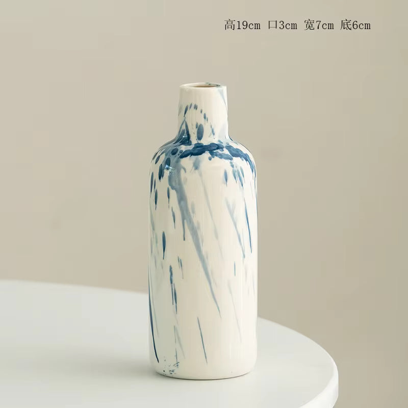 Marble-patterned ceramic vase on a white pedestal with a beige background