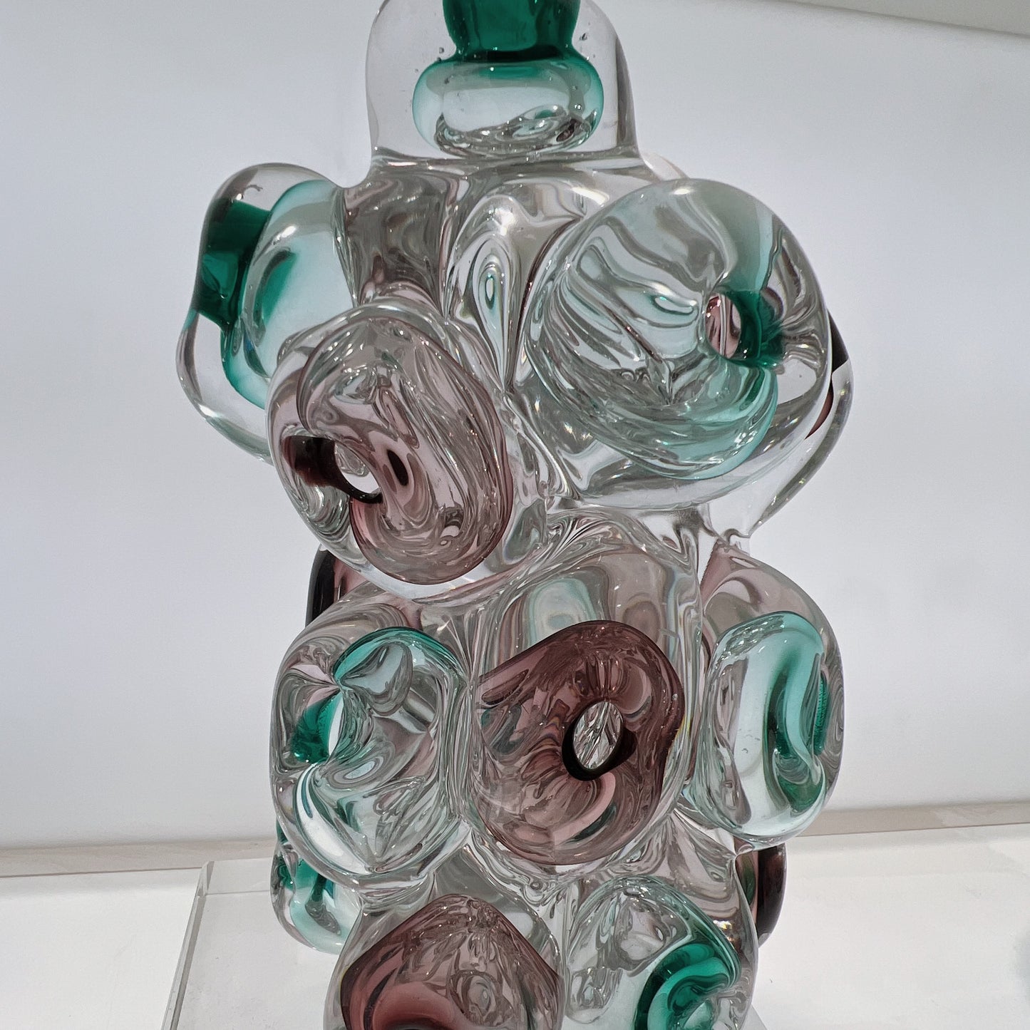 Glass sculpture with multicolored swirls on a white background
