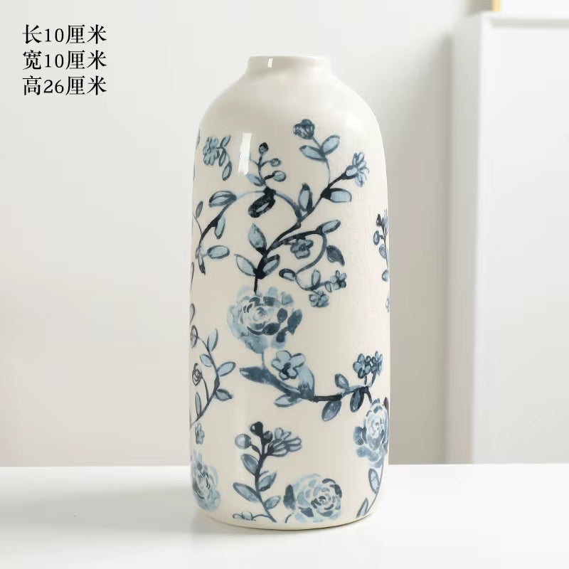 Cylindrical ceramic vase with blue floral patterns on a white background
