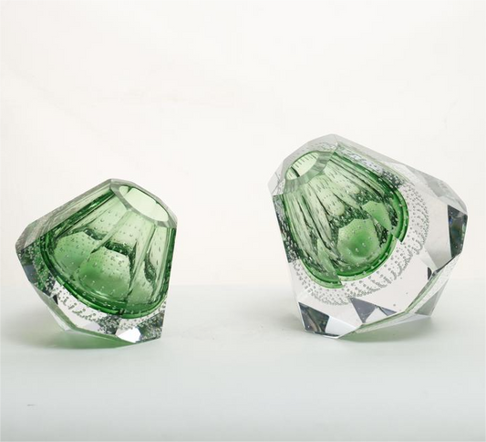 Two green crystal-like objects on a white background