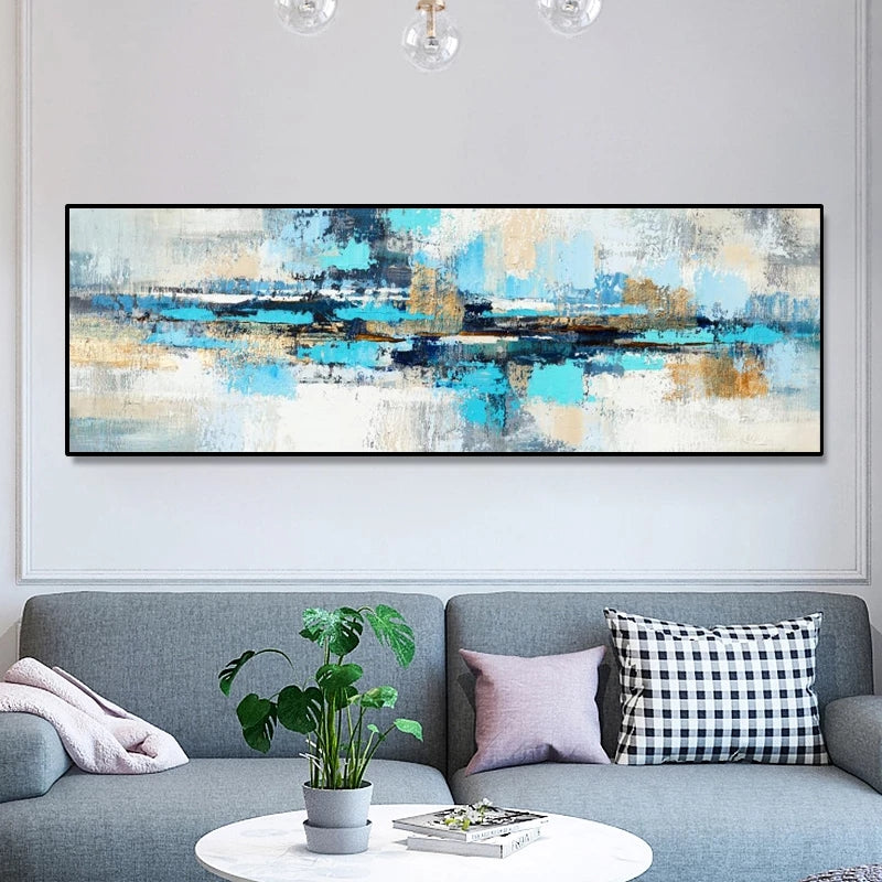 Abstract painting on a wall above a gray sofa with decorative pillows and a plant.