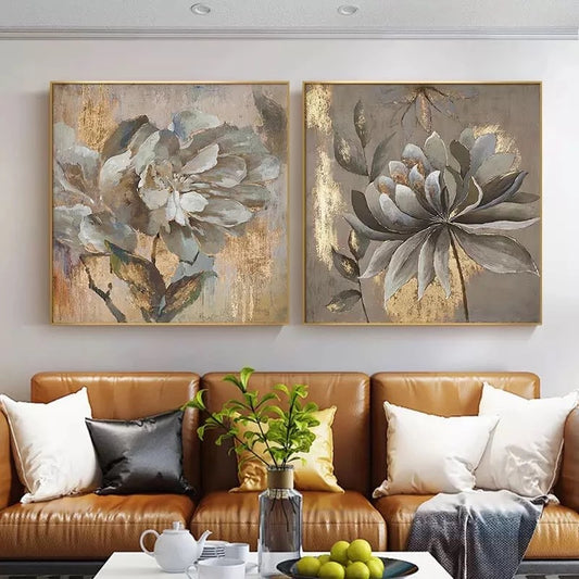Two floral paintings above a brown leather sofa in a living room.