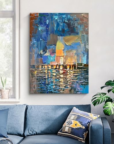 Abstract painting on a wall above a blue sofa with a decorative pillow.