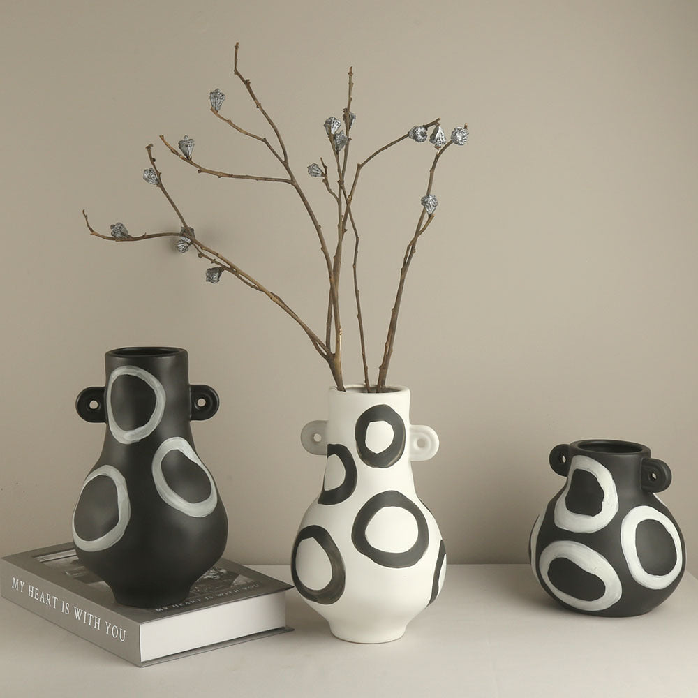 Three ceramic vases with circular patterns on a neutral background