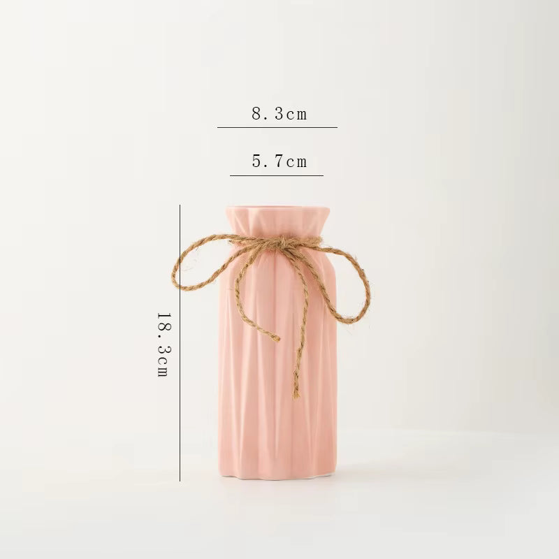 Pink ribbed vase with twine on a white background with measurements.