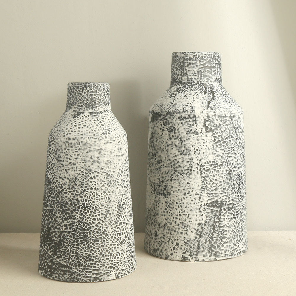 Two ceramic vases with a textured pattern on a neutral background