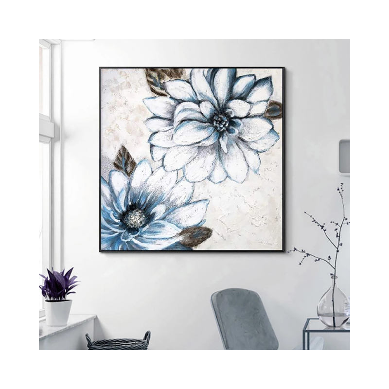 Framed artwork of blue flowers on a white wall with minimal decor.
