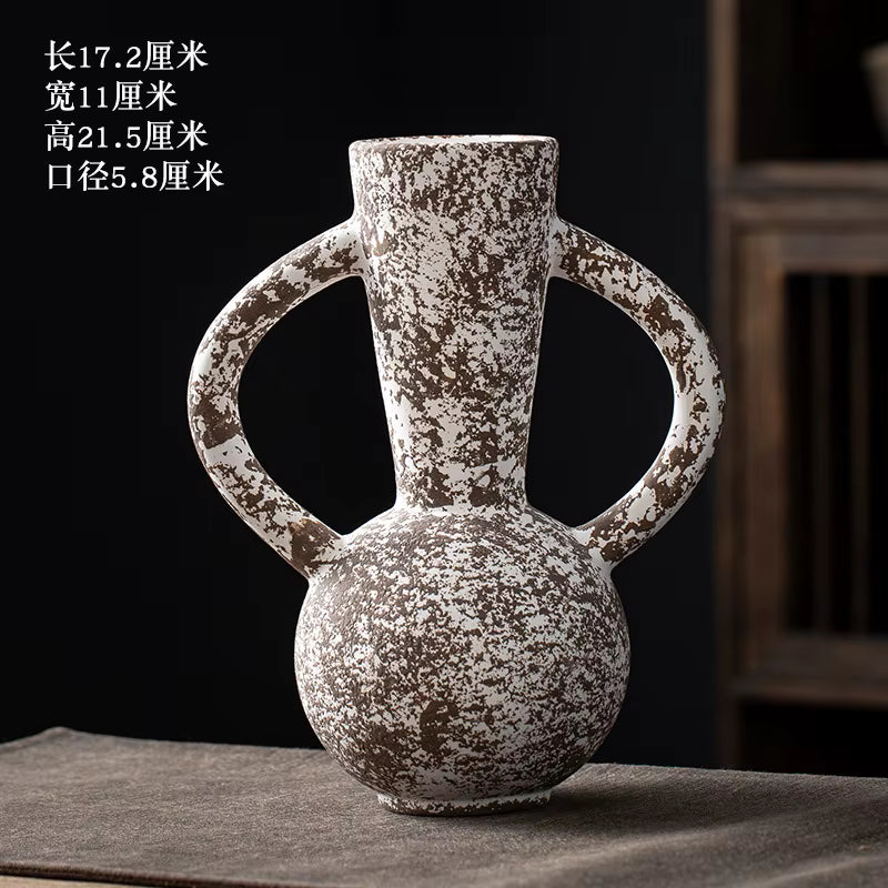 Decorative ceramic vase with handles on a dark surface