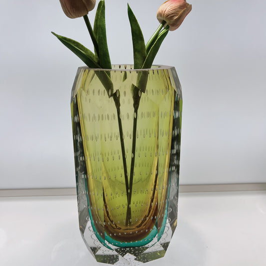 Decorative glass vase with floral arrangement on a white background