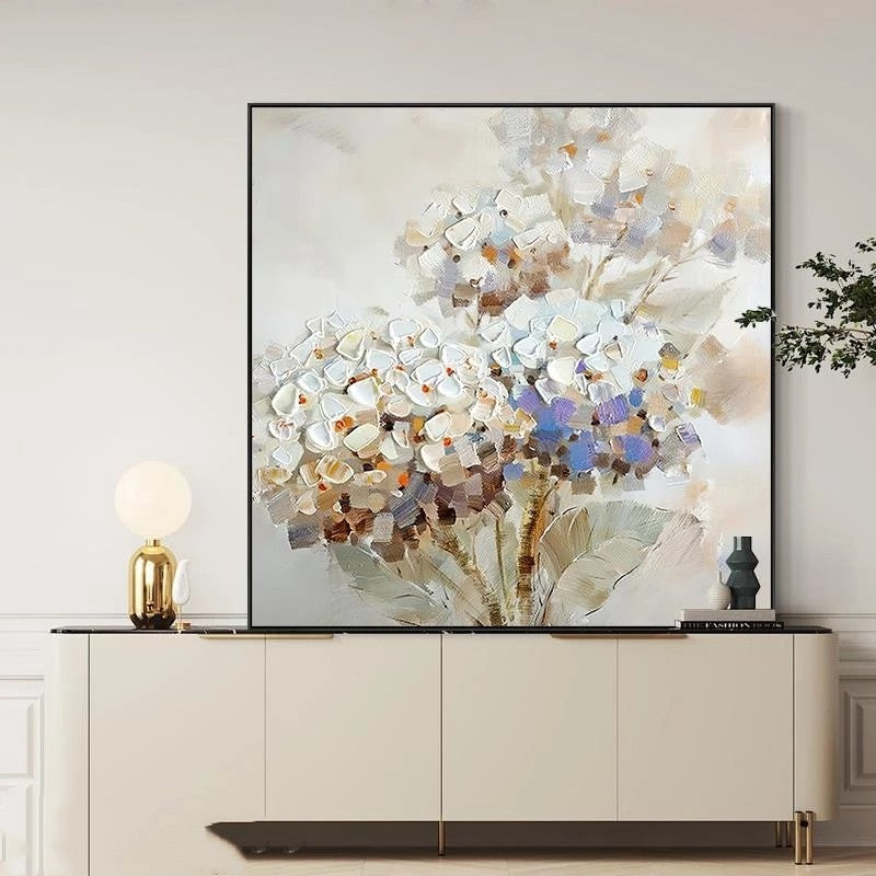 Abstract floral painting on a wall above a cabinet with decorative items.