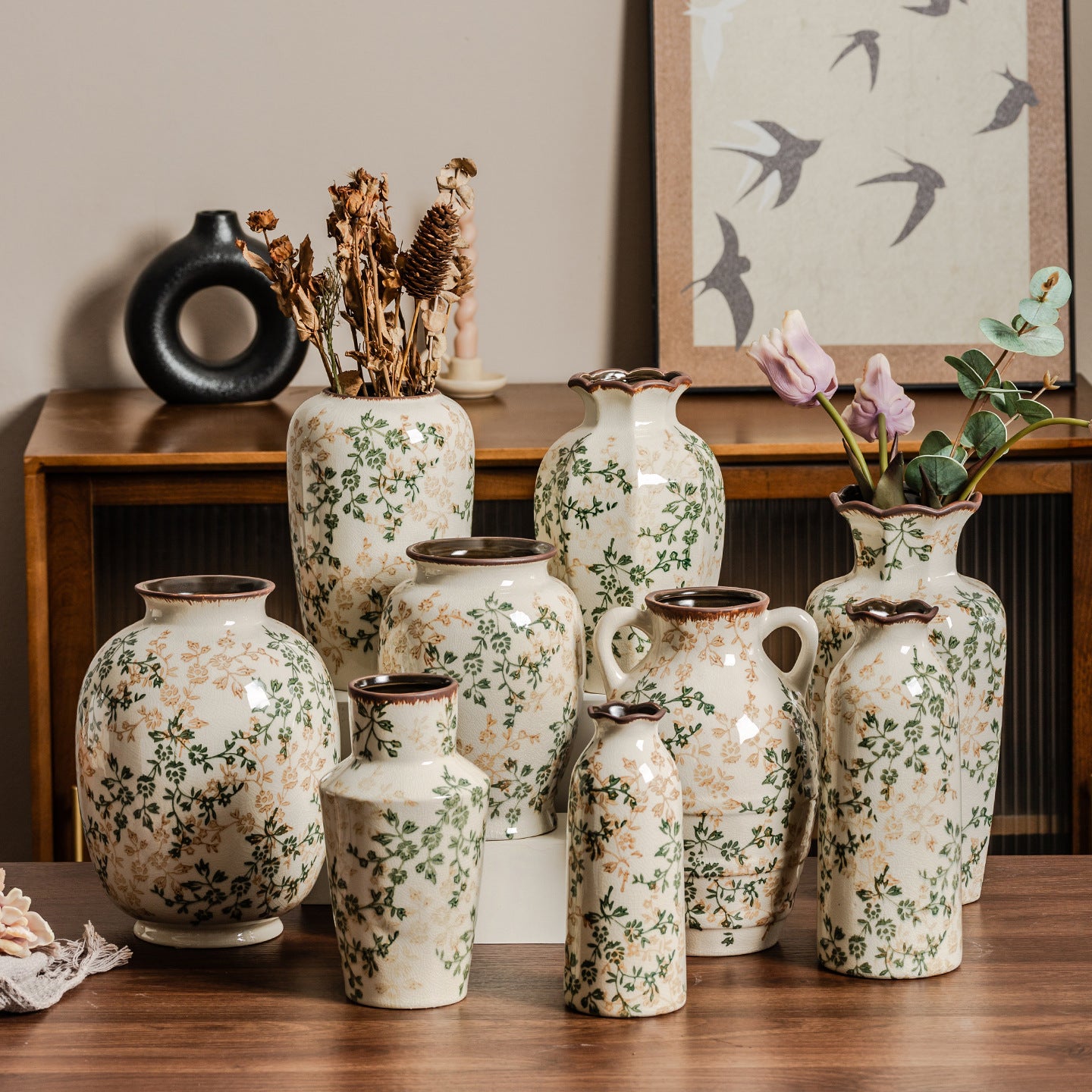 Collection of decorative vases with floral patterns on a wooden surface.
