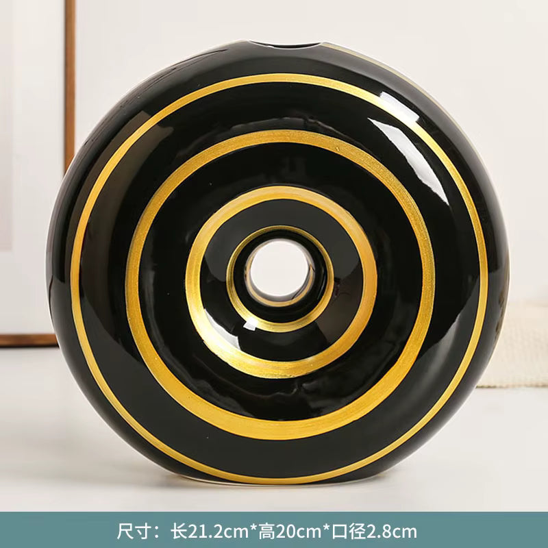 Black ceramic bowl with gold concentric circles on a white background