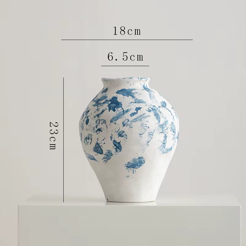 White ceramic vase with blue patterns and measurements on a light gray background
