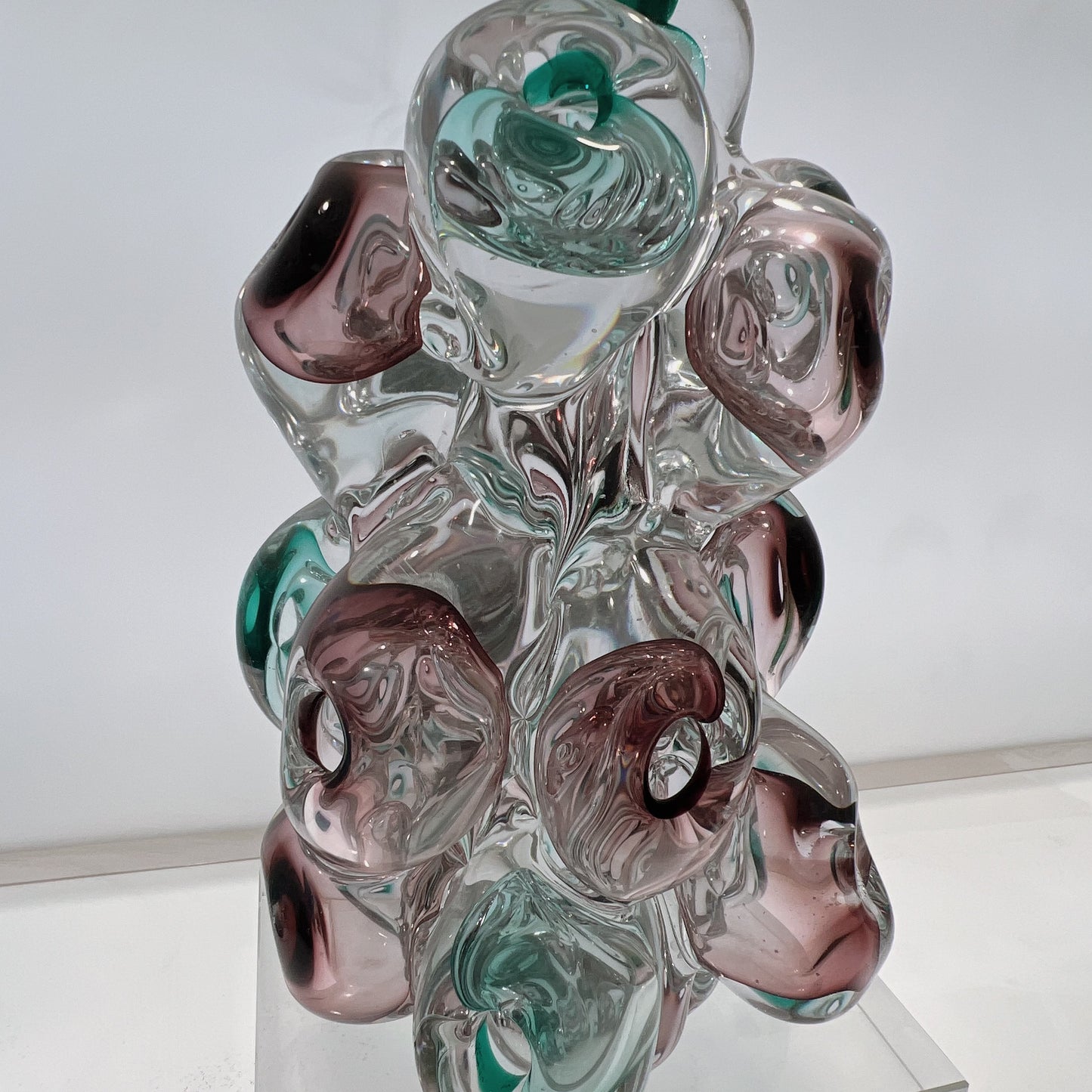 Glass sculpture with multicolored swirls on a white background