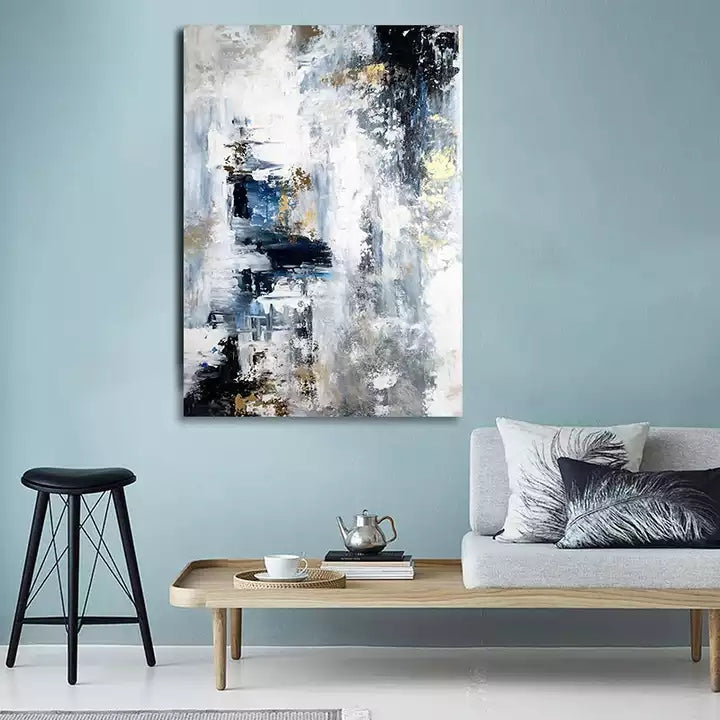Abstract painting on a wall above a sofa and coffee table in a living room.