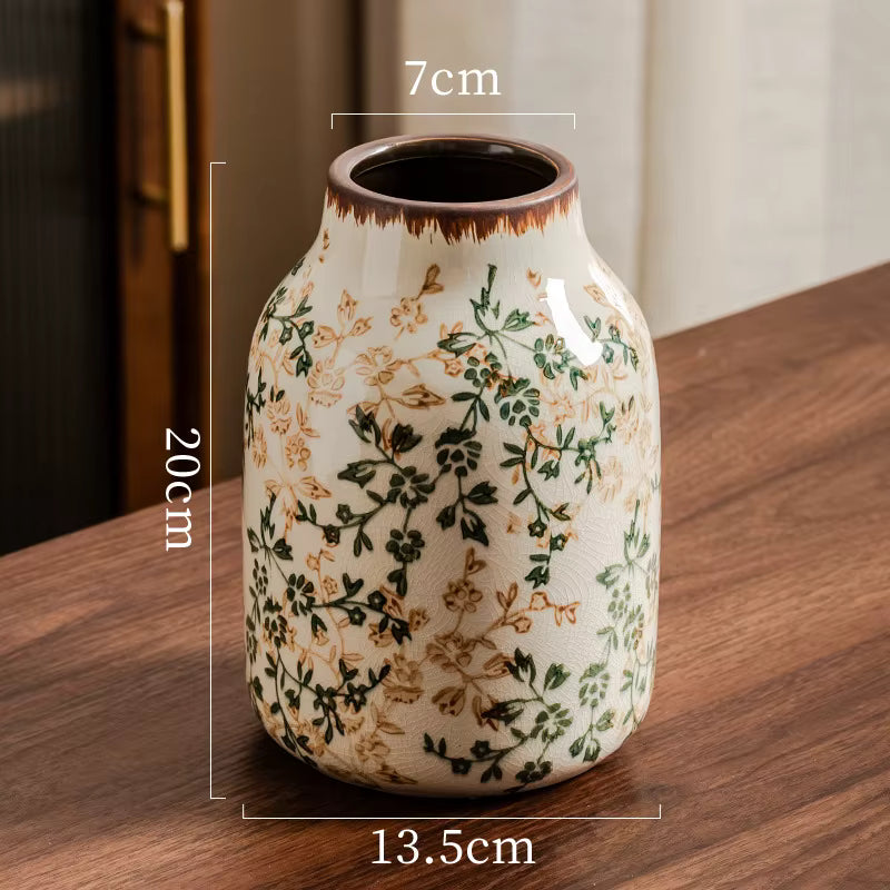 Ceramic vase with floral patterns on a wooden surface, showing measurements.