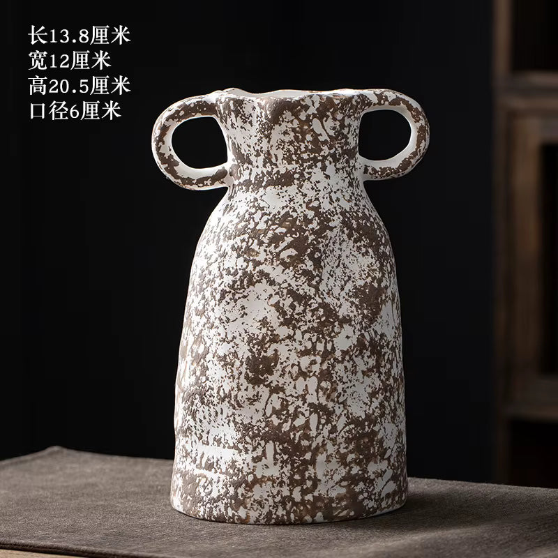 Decorative ceramic vase with handles on a dark surface