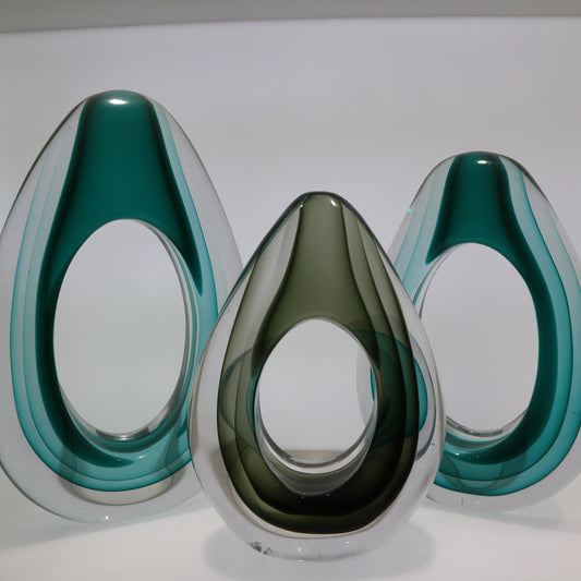 Three teardrop-shaped devices with a reflective surface on a white background