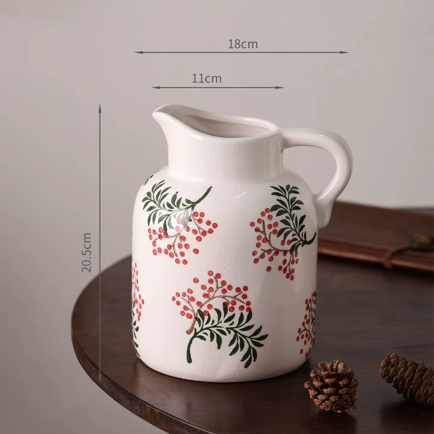 White ceramic pitcher with floral design on a wooden surface, with measurements indicated.