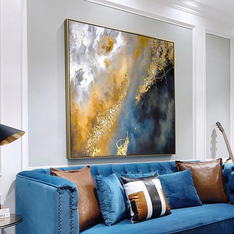 Blue sofa with decorative pillows in a room with abstract art on the wall.