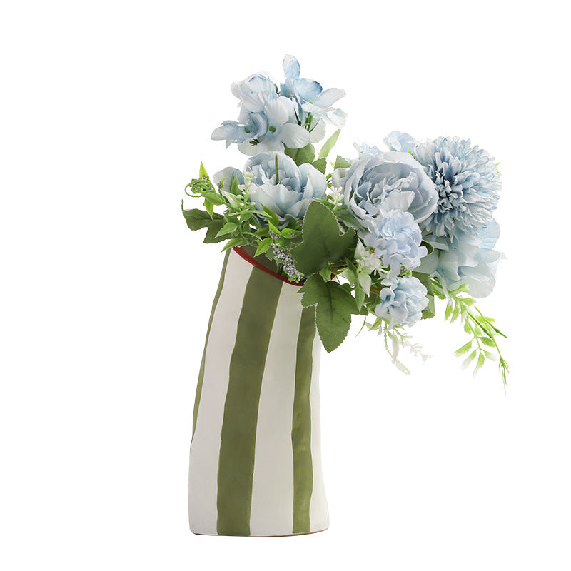 Striped vase with light blue flowers on a white background
