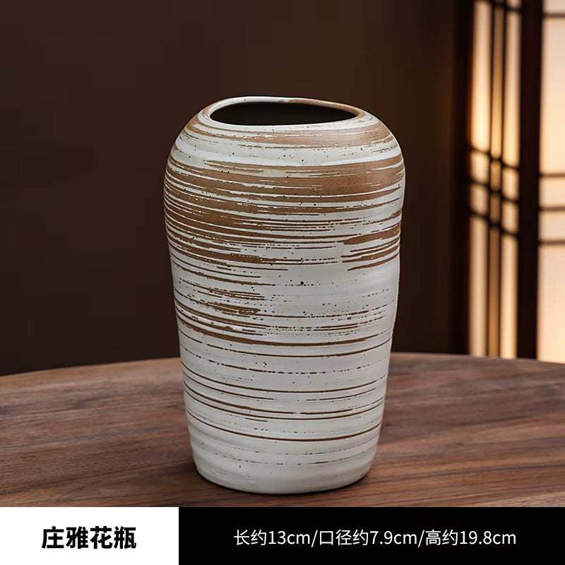Ceramic vase with striped design on a wooden surface