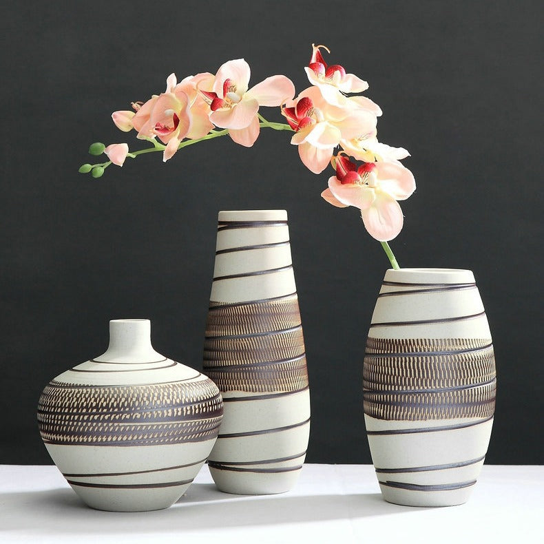 Three decorative vases with striped patterns on a dark background