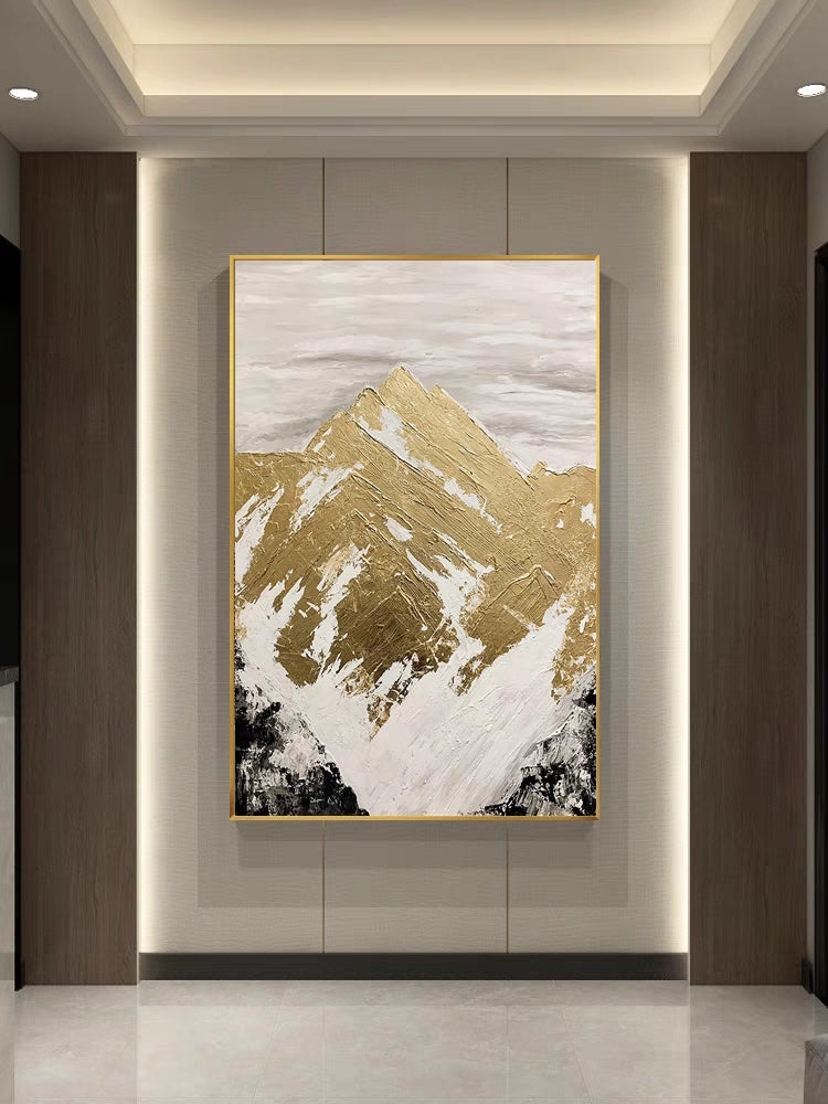 Abstract art piece with gold and white mountain design on a wall.