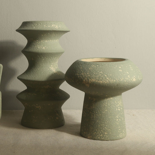 Two green ceramic vases on a neutral background