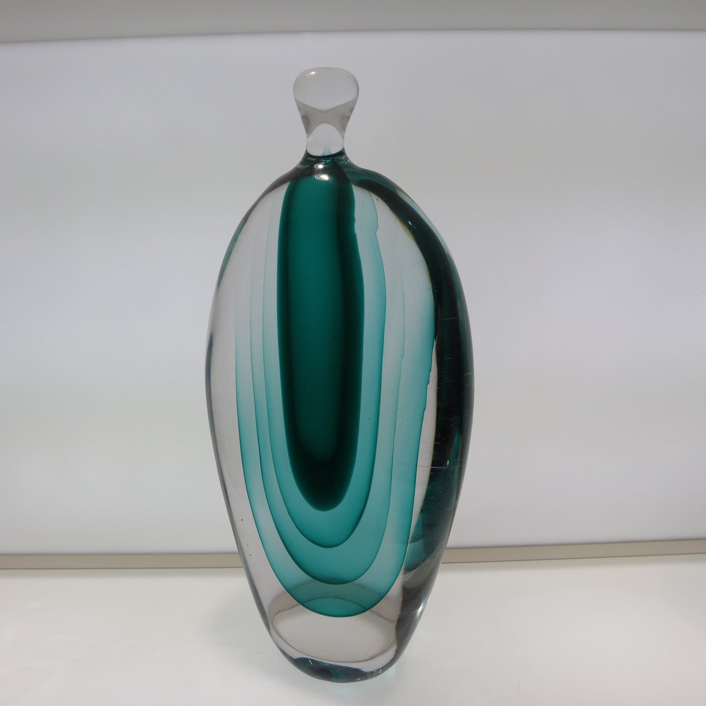 Glass vase with teal and clear design on a white background