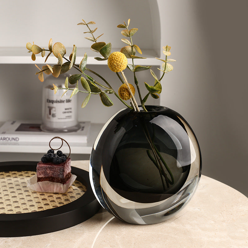 Black and silver vase with decorative plants on a table