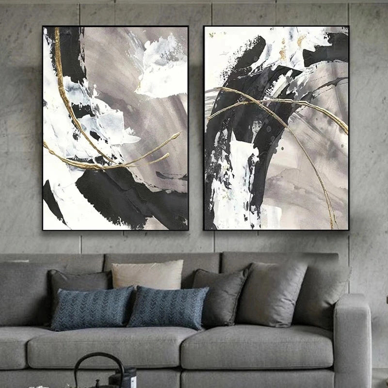 Two abstract art pieces on a wall above a gray sofa with decorative pillows.