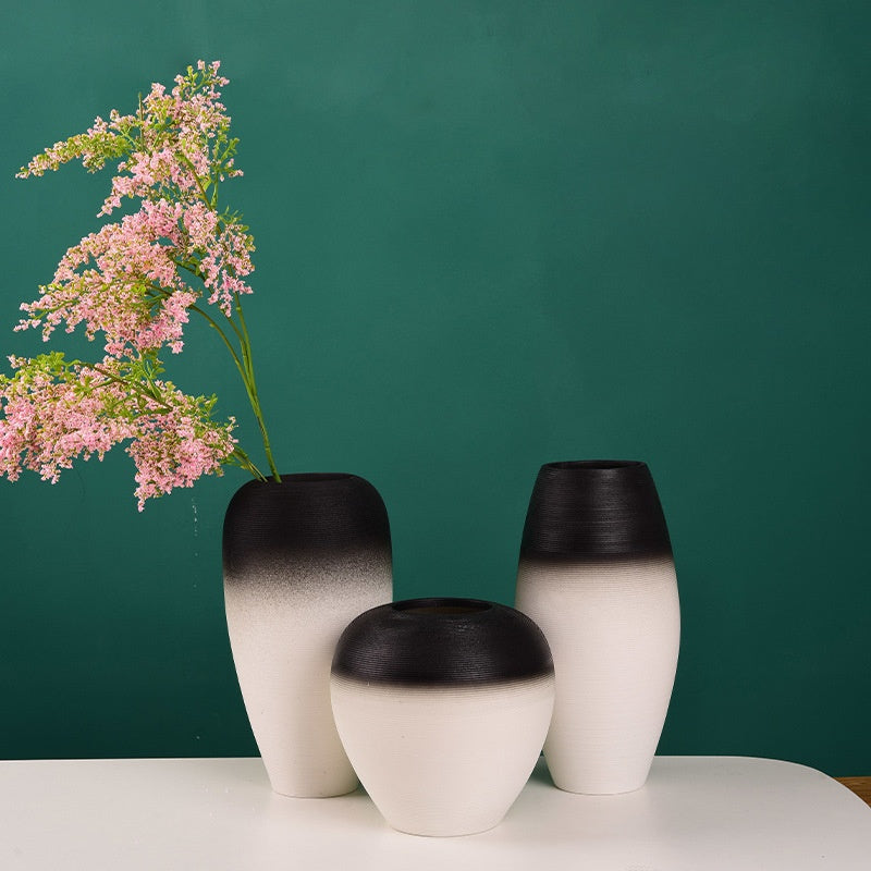 Three gradient vases with black and white design on a teal background