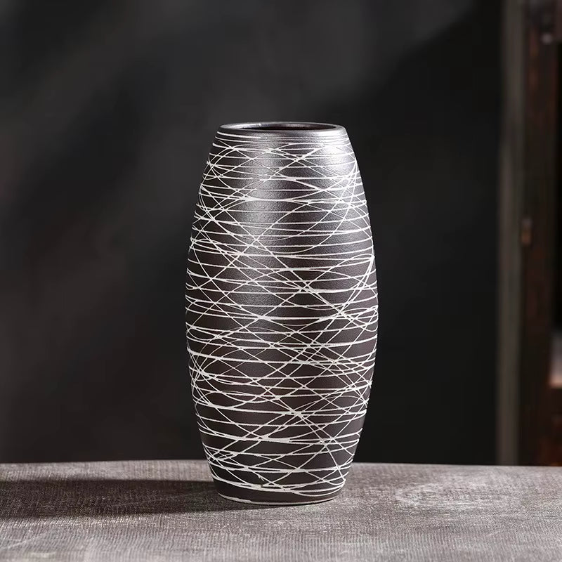 Decorative vase with black and white pattern on a dark background