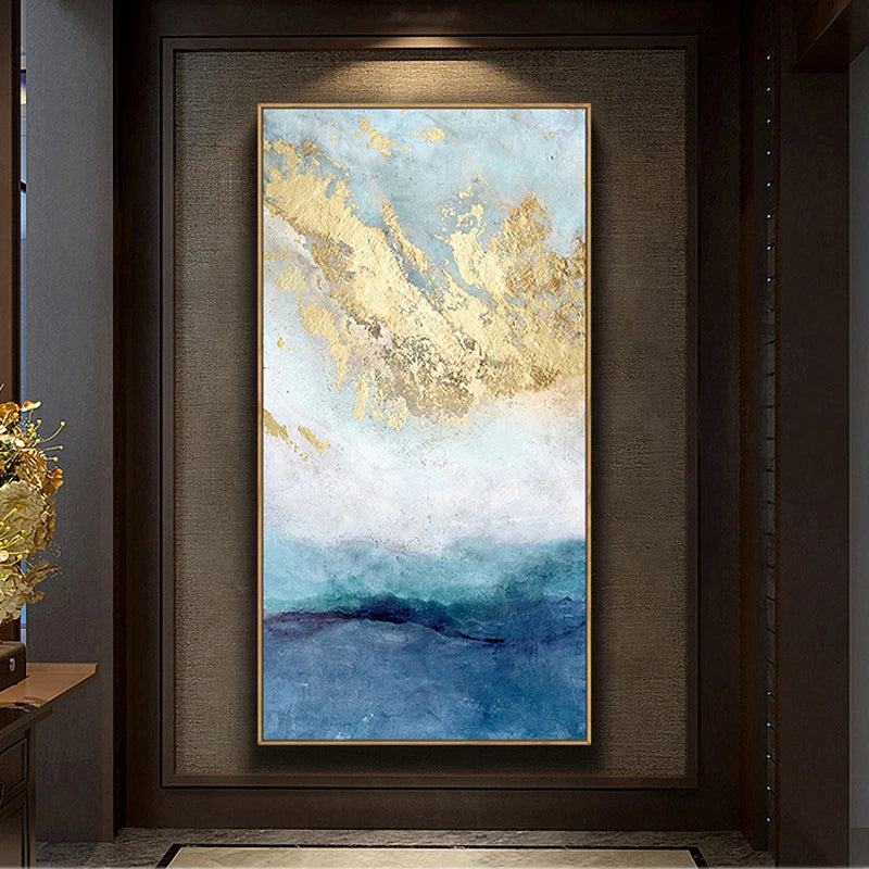 Framed abstract painting with gold and blue tones on a wall.