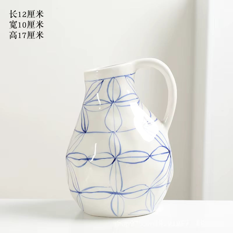 White ceramic pitcher with blue floral patterns on a white background