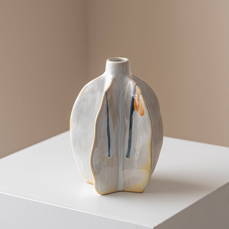 Ceramic vase with abstract design on a white surface and beige background