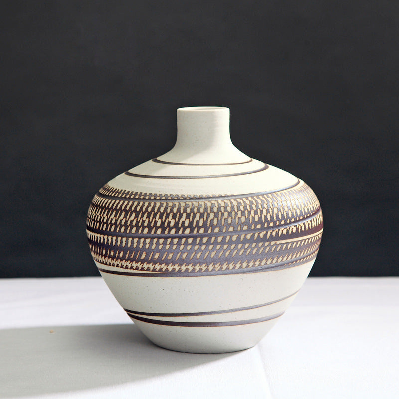 Ceramic vase with striped pattern on a white surface and black background