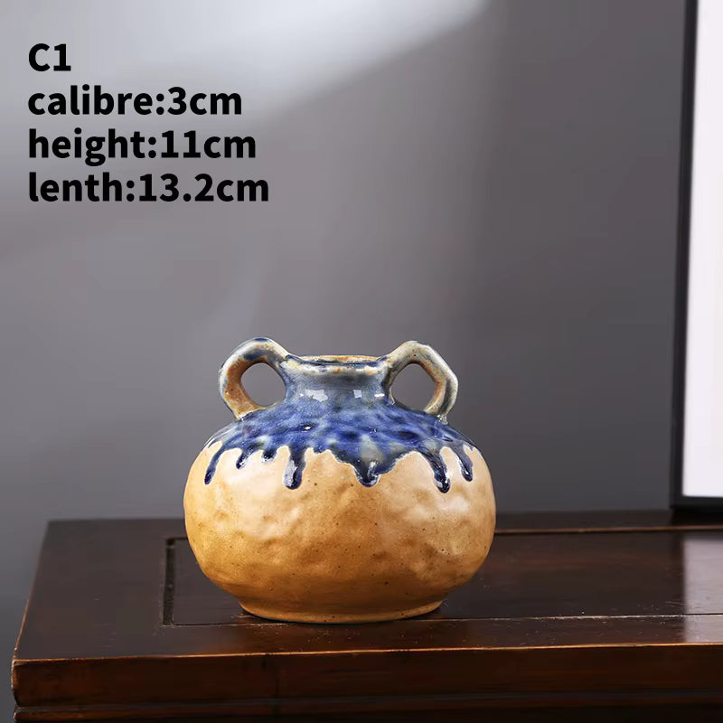 Ceramic vase with blue glaze on a wooden surface against a gray background