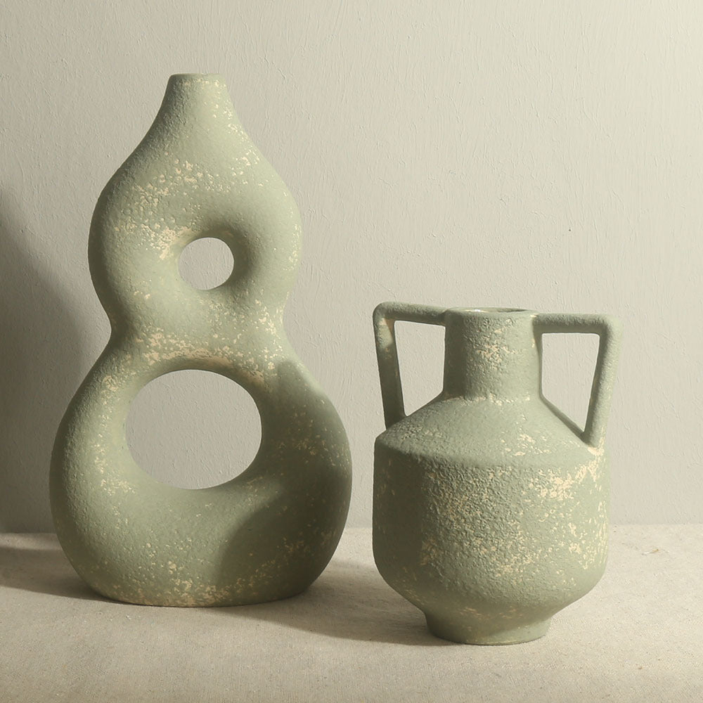 Two green ceramic vases on a neutral background