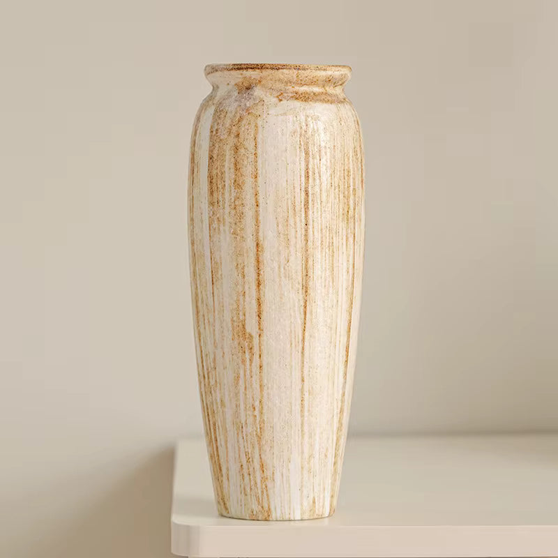 Tall ceramic vase with striped pattern on a neutral background