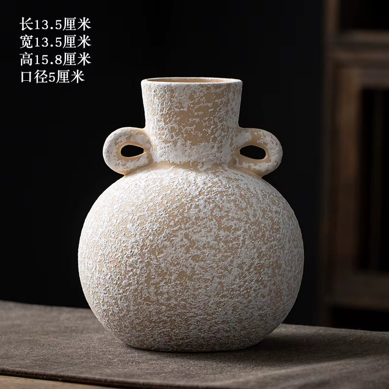 Textured ceramic vase with two handles on a dark surface