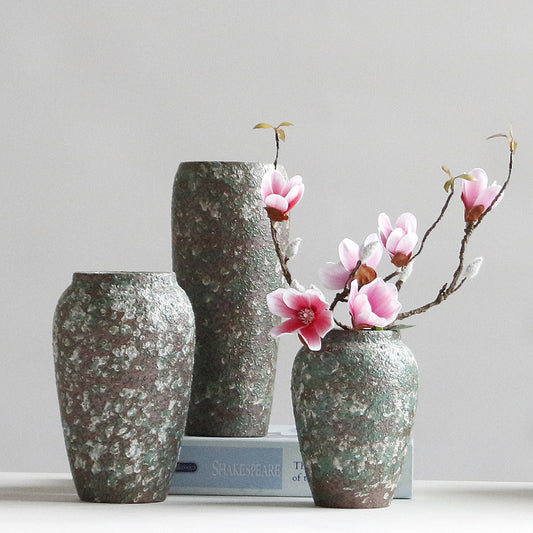 Three decorative vases with floral arrangements on a light gray background